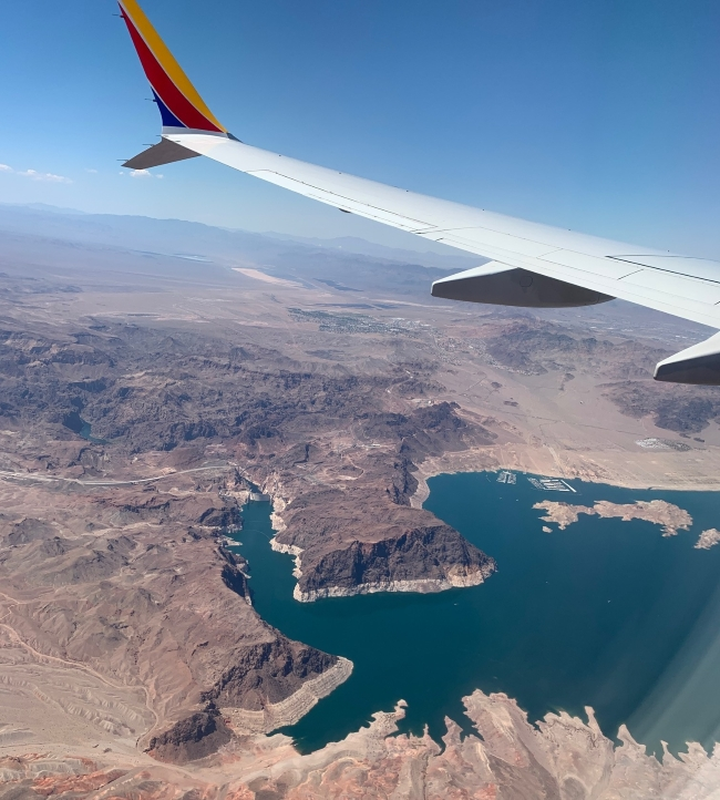 Airplane flying over mountains and a lake during a trip to visit a long-distance friend